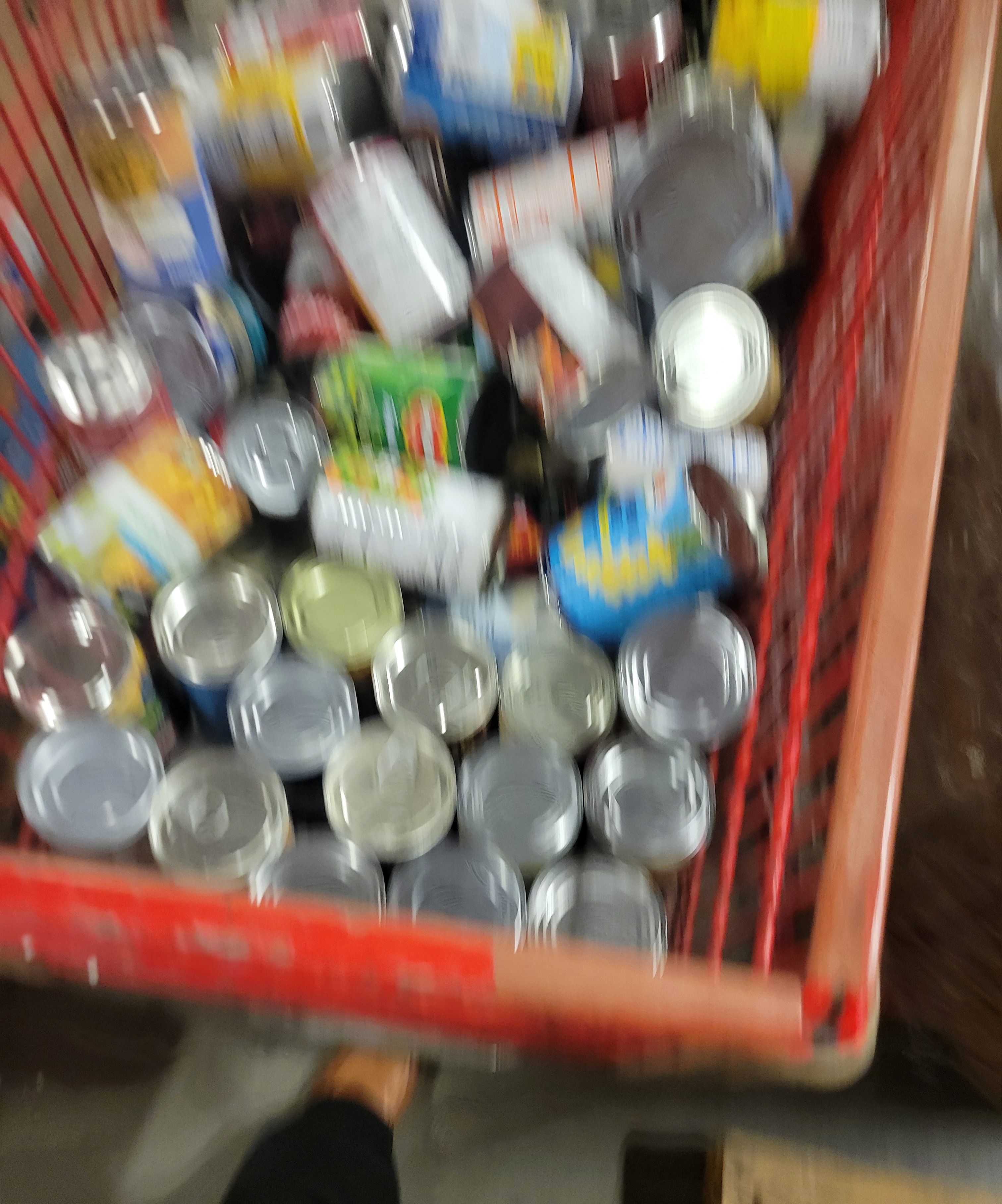Red caged mail cart filled with canned goods.